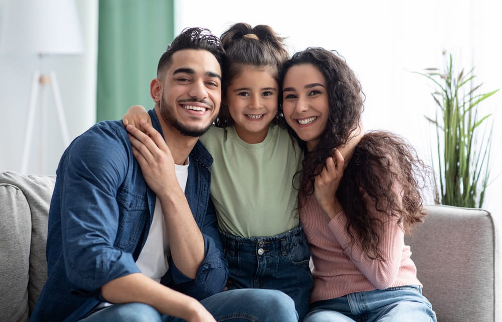 Portrait of a happy family sitting together and smiling, highlighting the importance of family-friendly dental care that supports lifelong oral health - Dentist In San Jacinto, CA.
